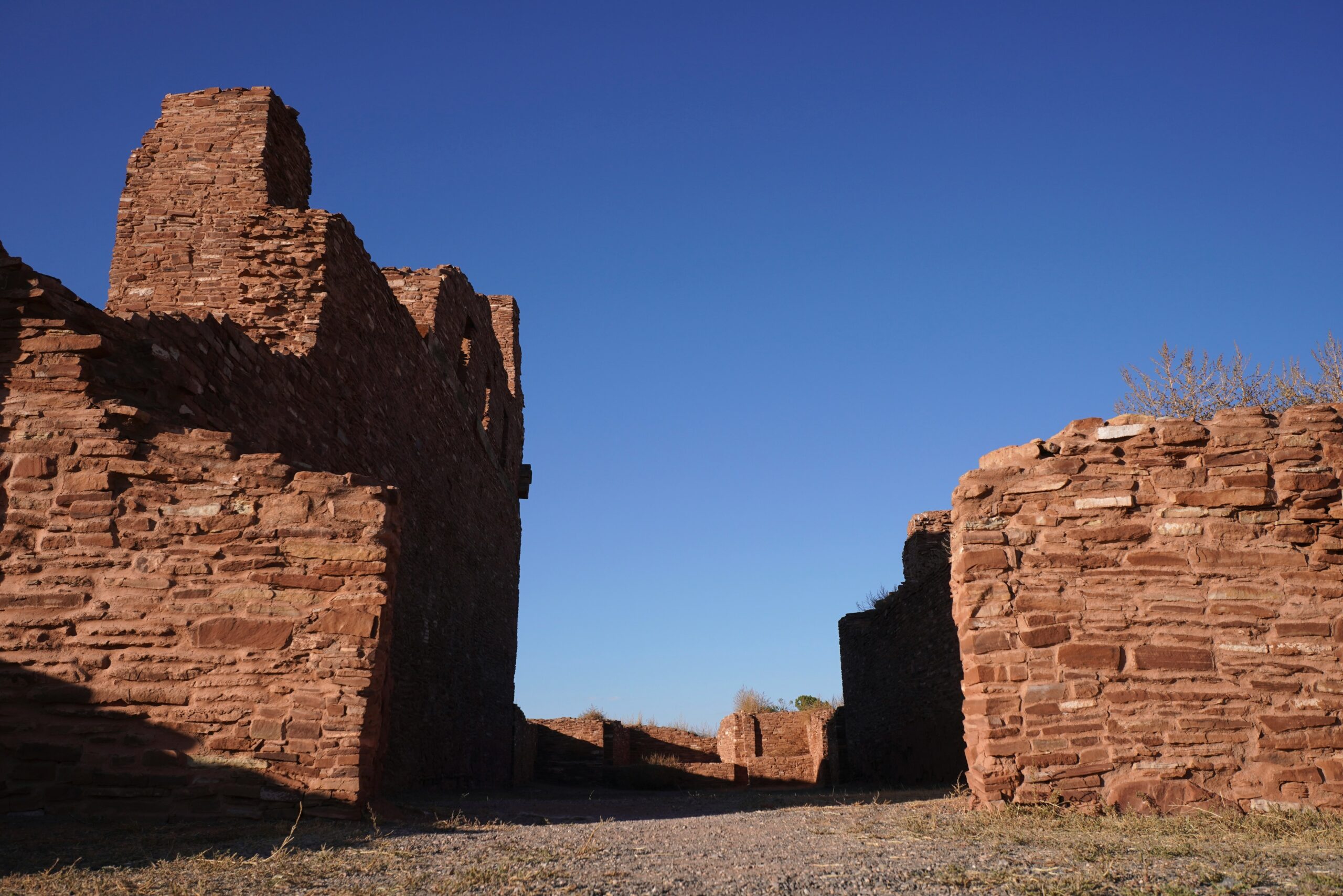 A large brick building sitting on top of a dry grass field