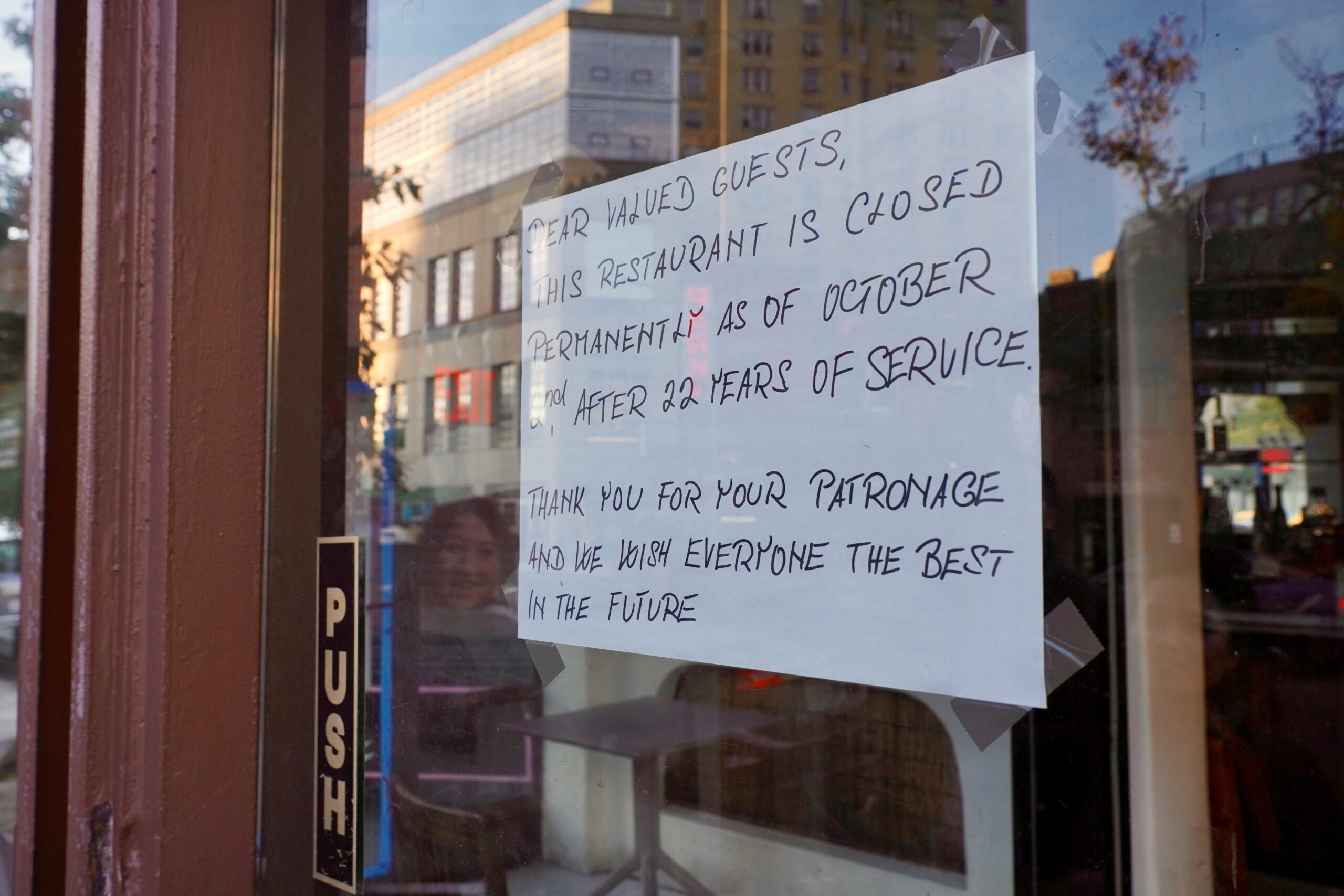 A sign posted on the door of a restaurant