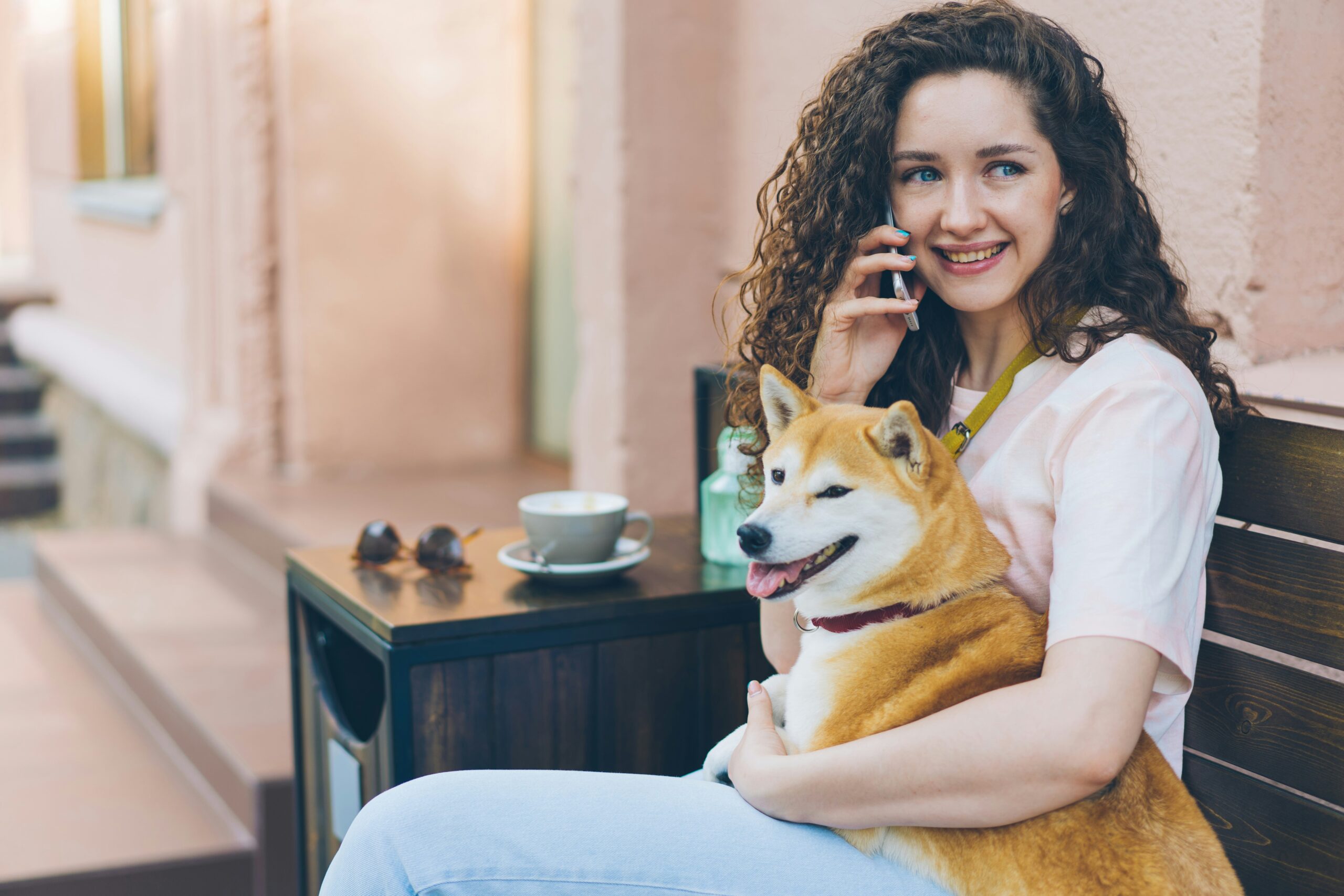 a woman sitting on a bench with a dog on her lap